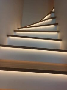Dębowe schody z białą podstopnicą i oświetleniem Led. Wykończenie olejowosk w kolorze surowego drewna. Realizacja schody Poznań