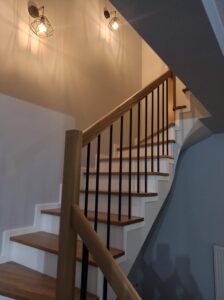 Dębowe schody z białą podstopnicą. Wykończenie olejowosk w kolorze naturalnego drewna. Realizacja schody Poznań